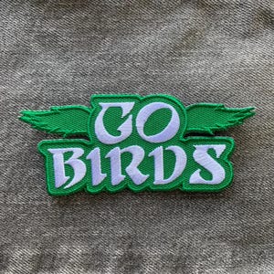 May include: Green and white embroidered patch with the words "GO BIRDS" and a green bird wing design.