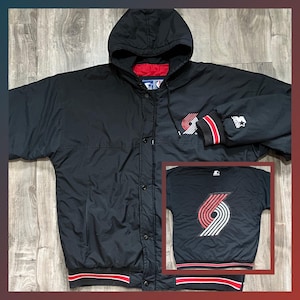 May include: Black hooded jacket with a red and white logo on the front. The logo is a stylized 'S' with a red and white stripe pattern. The jacket has a zipper closure and a drawstring hood. The jacket is made by Starter.