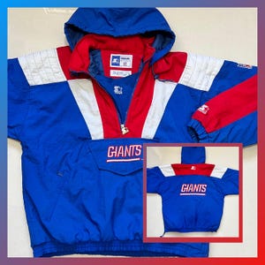 Può includere: Giacca a vento Starter vintage blu, rossa e bianca con la scritta "GIANTS" sul petto. La giacca ha un cappuccio, una mezza zip e una tasca frontale. Le maniche hanno dettagli rossi e bianchi.