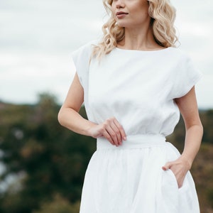 Linen wedding dress, close-up front view with hand on waist