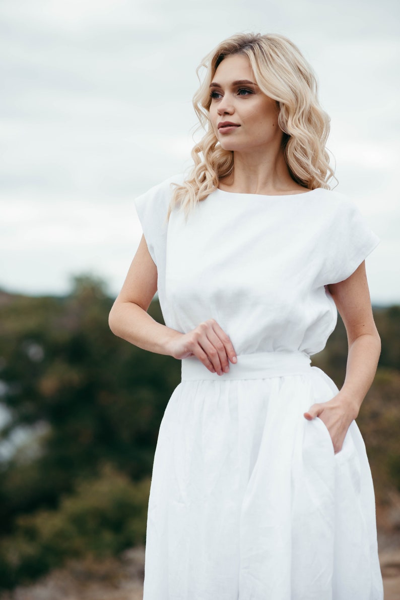 Linen wedding dress, close-up front view with hand on waist
