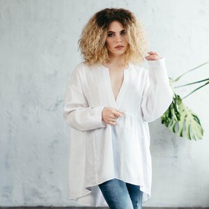 Front view of a crisp white oversized linen shirt for women, featuring a classic cut and minimalist design.