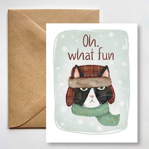 May include: A black and white cat wearing a red and black plaid hat with a brown fur trim and a green scarf. The cat is looking at the viewer with a grumpy expression. The background is a light blue with snowflakes. The text "Oh, what fun" is written in red above the cat.