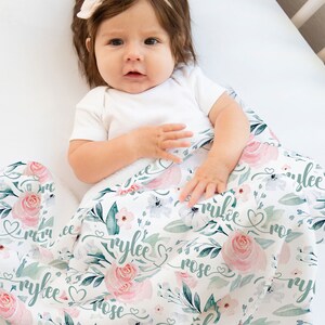 May include: A white baby blanket featuring a floral design and the name "Rylee Rose" written in cursive. The blanket is made from soft, breathable fabric, ideal for snuggling.