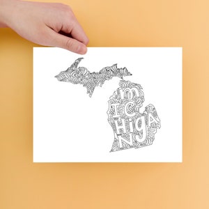 Op de afbeelding: Een zwart-witte printbare kleurplaat met een omtrek van de staat Michigan, waarbij het woord "Michigan" binnen de grenzen van de staat is gespeld.