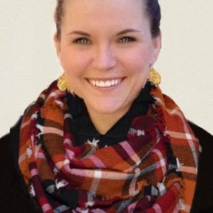 May include: A red, orange, black, and white plaid infinity scarf with frayed edges.
