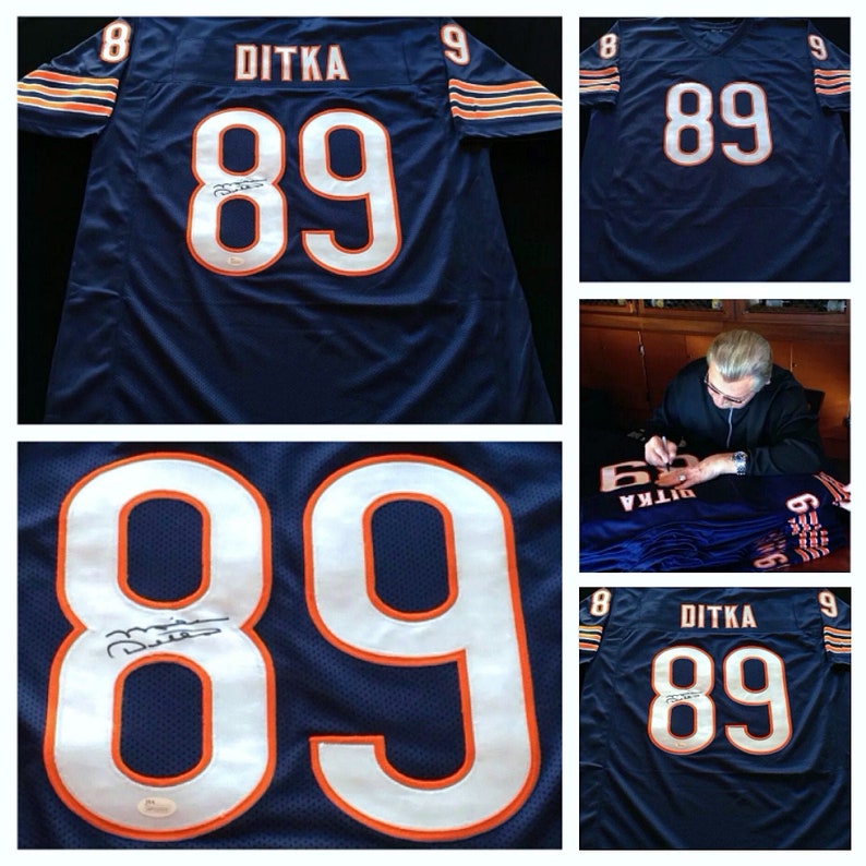 K&ouml;nnte beinhalten: Marineblaues Football-Trikot mit dem Namen "DITKA" und der Nummer "89" in Wei&szlig; mit orangefarbenem Rand. Das Trikot hat eine Unterschrift auf der Nummer. Die &Auml;rmel haben orange und wei&szlig;e Streifen.