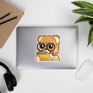 May include: A cartoon illustration of a brown bear wearing glasses and a white shirt, holding a yellow notepad and a pink pencil.