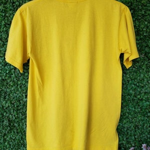 May include: A plain yellow short-sleeved t-shirt with a crew neck.