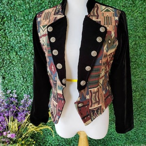 May include: A black velvet jacket with a colorful patterned fabric on the front and back. The jacket has a stand-up collar and button closures.