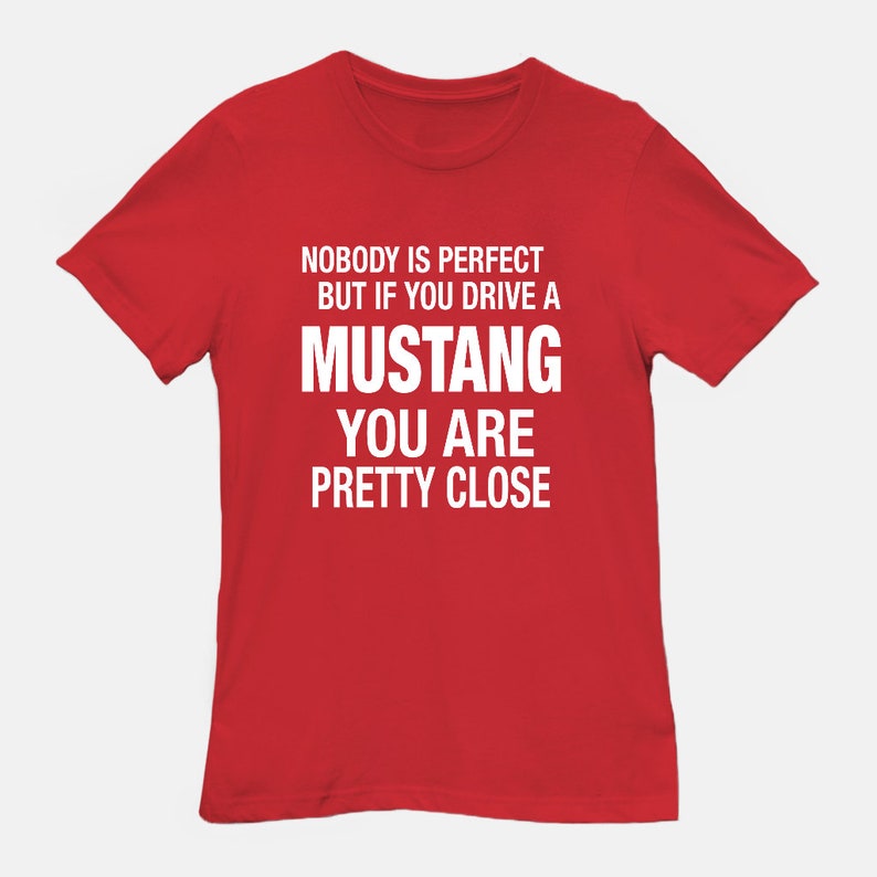May include: Red t-shirt with white text that reads "Nobody is perfect but if you drive a Mustang you are pretty close."