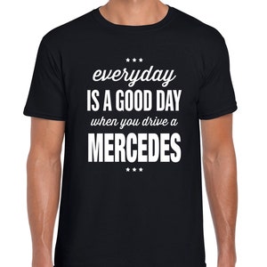 Op de afbeelding: Zwart T-shirt met witte tekst die "everyday is a good day when you drive a MERCEDES" zegt.