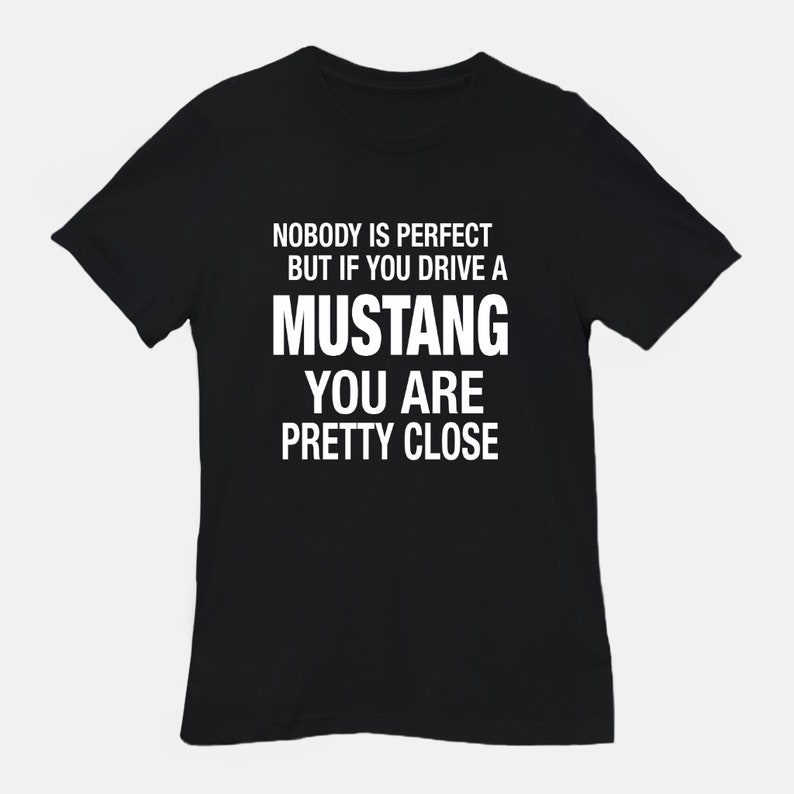 May include: Black t-shirt with white text that reads "Nobody is perfect but if you drive a Mustang you are pretty close."