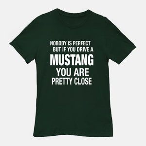 May include: A dark green t-shirt with white text that reads "Nobody is perfect but if you drive a Mustang you are pretty close."