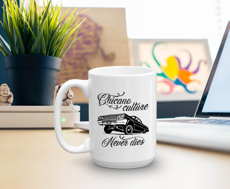 K&ouml;nnte beinhalten: Wei&szlig;e Keramiktasse mit einer Schwarzwei&szlig;illustration eines Lowrider-Autos und dem Text "Chicano culture never dies".