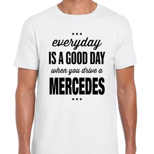 Op de afbeelding: Wit T-shirt met zwarte tekst die "everyday is a good day when you drive a MERCEDES" luidt.