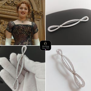 Peut inclure: Broche argentée en forme de nœud, ornée de petits diamants transparents. La broche a une forme allongée avec une torsion centrale. L'image présente la broche sur des fonds noirs et blancs. Une femme portant une broche similaire est également visible.