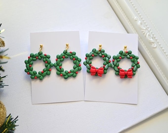 May include: Green wreath earrings with red berry accents and gold-colored posts. One pair features a red bow. Festive holiday jewelry, perfect for Christmas or winter. Each earring is approximately 1 inch in diameter.