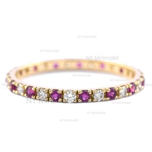 May include: A gold band ring with a row of alternating ruby and diamond stones.