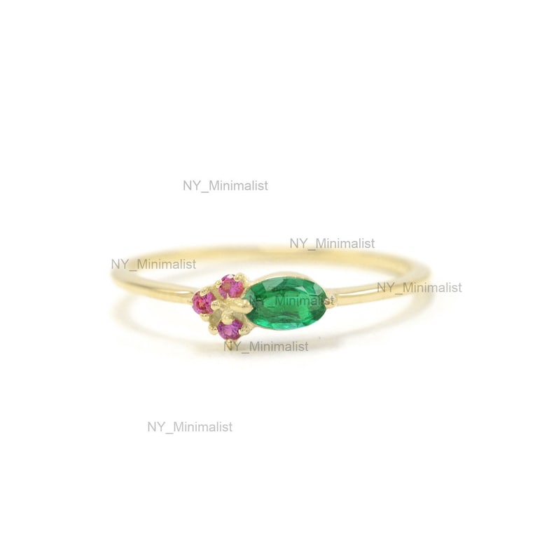 May include: A gold ring with a green oval gemstone and pink gemstones. The ring is simple and elegant.