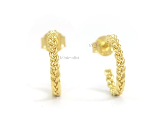 May include: A pair of gold braided hoop earrings. The earrings are small and delicate, and they have a simple, minimalist design.