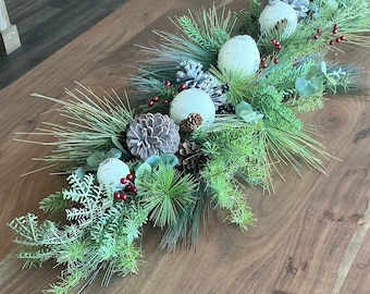 Pièce maîtresse de Noël, décor de table longue, boules de bouleau, baies de houx rouges, verdure à feuilles persistantes de pomme de pin, salle à manger sur table basse, décor de cheminée