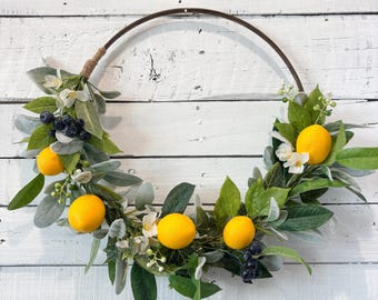 Corona de limones, follaje artificial, aro de madera, oreja de cordero, arándanos.