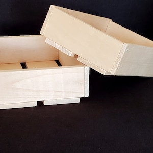 May include: Two unfinished wooden boxes, one stacked on top of the other. The boxes are square and have a simple design.