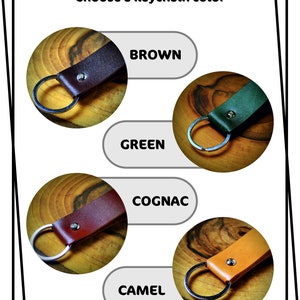 May include: Four leather keychains in different colors: brown, green, cognac, and camel. Each keychain has a silver key ring.