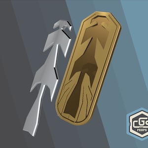 Puede incluir: Un escudo de metal dorado con un dise&ntilde;o de flecha estilizado. El escudo est&aacute; ligeramente inclinado y tiene un borde elevado. El dise&ntilde;o de la flecha est&aacute; en un tono dorado m&aacute;s oscuro. El escudo est&aacute; sobre un fondo gris.