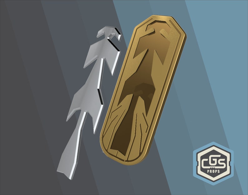 Puede incluir: Un escudo de metal dorado con un dise&ntilde;o de flecha estilizado. El escudo est&aacute; ligeramente inclinado y tiene un borde elevado. El dise&ntilde;o de la flecha est&aacute; en un tono dorado m&aacute;s oscuro. El escudo est&aacute; sobre un fondo gris.