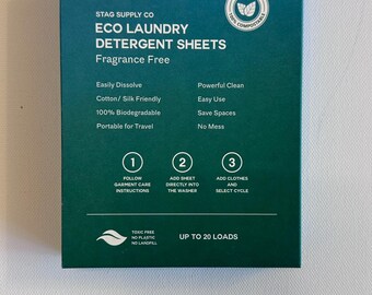 Può includere: Una scatola verde di fogli di detersivo per bucato ecologici. La scatola dice "Stag Supply Co. Eco Laundry Detergent Sheets Fragrance Free" e elenca caratteristiche come "Facile da sciogliere", "Adatto a cotone/seta", "100% biodegradabile", "Trasportabile per viaggi", "Pulizia potente", "Facile da usare", "Risparmio di spazio" e "Nessun disordine". La scatola dice anche "Fino a 20 carichi" e ha un logo di foglia verde che dice "Eco Friendly 100% Compostable".