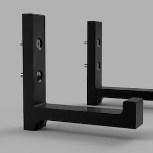 Puede incluir: Dos soportes de estante de metal negro para montar en la pared. Cada soporte tiene dos agujeros para tornillos en la parte vertical y un borde curvo en la parte horizontal.