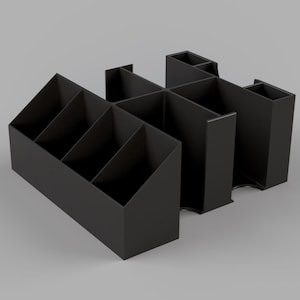 May include: Black plastic desk organizer with multiple compartments. The organizer has a rectangular shape and is divided into several sections.