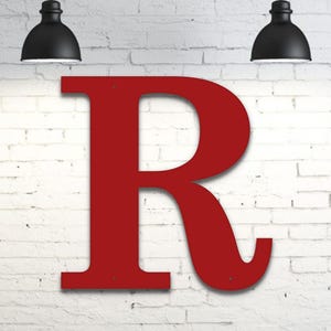 May include: A large, flat, capital letter R in a deep red color. The letter features a classic serif typeface design with clean, smooth edges and three small, circular mounting holes positioned at the top, bottom left, and bottom right corners.