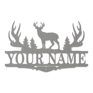 May include: A silver metal sign with a deer silhouette, two trees, and antlers on either side. The sign says "YOUR NAME" in a decorative font.