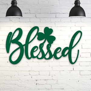 May include: Green metal wall decor with the word "Blessed" in a cursive font and a shamrock design.