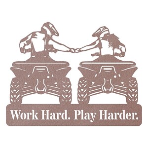 May include: A metal silhouette of two people riding quad bikes, holding hands, with the text "Work Hard. Play Harder." below. The silhouette is brown.