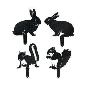 Pu&ograve; includere: Quattro sagome di animali in metallo nero: un coniglio, un coniglio, uno scoiattolo e uno scoiattolo. Le sagome sono montate su picchetti per la decorazione da giardino all'aperto.
