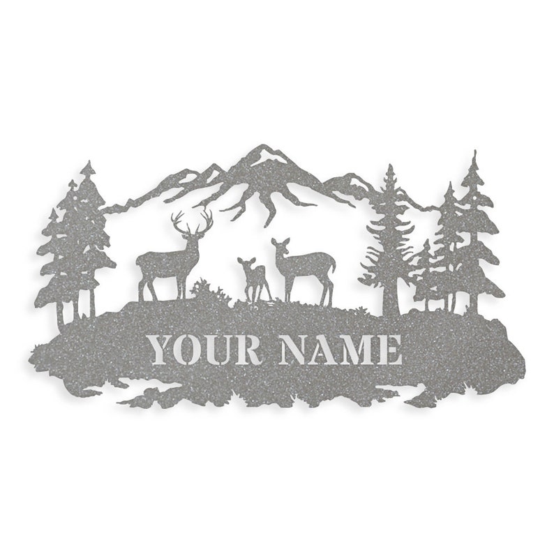 May include: A metal silhouette of a mountain range with three deer, two adult and one fawn, standing in front of a forest. The text "YOUR NAME" is below the deer.