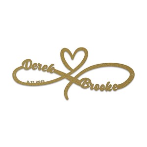 May include: Gold infinity symbol with a heart in the centre. The names Derek and Brooke are written on either side of the symbol. The date 8.17.2013 is written below Derek's name.