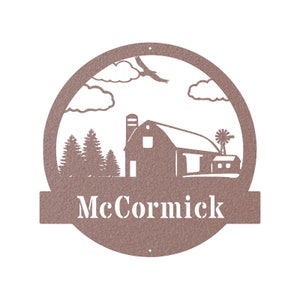 May include: A brown metal sign with a farmhouse silhouette, clouds, and a windmill. The sign has a banner at the bottom with the name "McCormick" in white lettering.