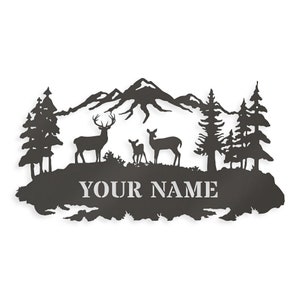 May include: Black metal silhouette of a mountain range with three deer, two adult and one fawn, standing in front of a forest. The text "YOUR NAME" is below the deer.