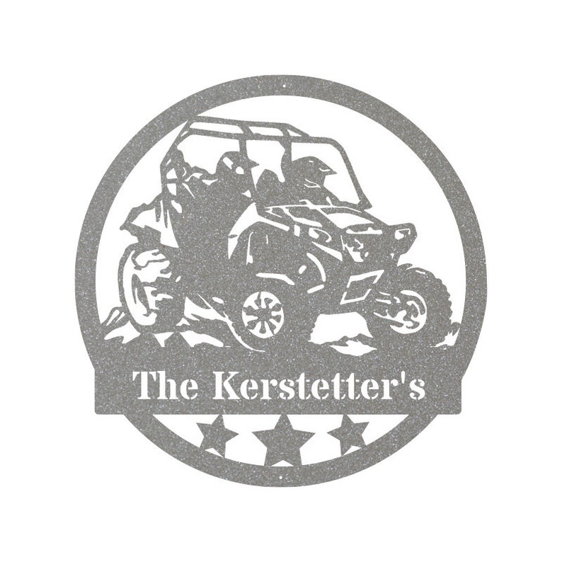 May include: A gray metal silhouette of a side-by-side off-road vehicle with two people inside. The vehicle is driving over a hill and has a white text banner below that reads "The Kerstetter's" with five stars.