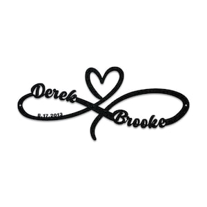 May include: Black metal infinity symbol with a heart in the centre. The names "Derek" and "Brooke" are written on either side of the symbol, with the date "8.17.2013" below "Derek".
