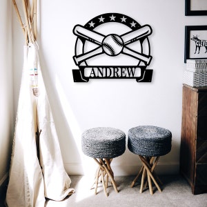 K&ouml;nnte beinhalten: Schwarze Baseball-Wanddekoration aus Metall mit gekreuzten Schl&auml;gern und einem Baseball in der Mitte. Der Name "ANDREW" ist auf einem Banner unter dem Baseball abgebildet.