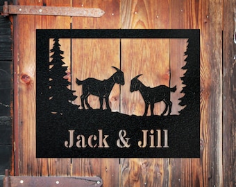 May include: Black metal sign with two goats silhouetted against a pine tree backdrop. The sign reads "Jack & Jill".