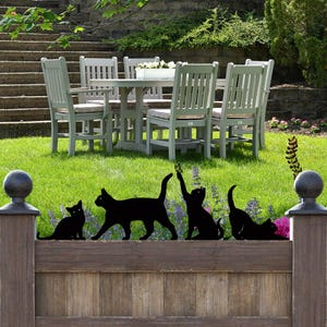a group of cats sitting on top of a lush green field