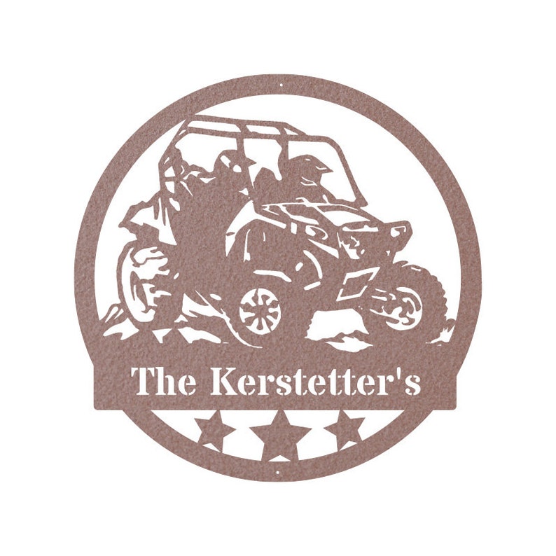 May include: A brown metal silhouette of a side-by-side off-road vehicle with two people inside. The vehicle is driving over a hill. The silhouette is surrounded by a circle with five stars and the text "The Kerstetter's".