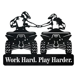 May include: Black and white silhouette of two people riding quad bikes, holding hands. The text "Work Hard. Play Harder." is below the quad bikes.
